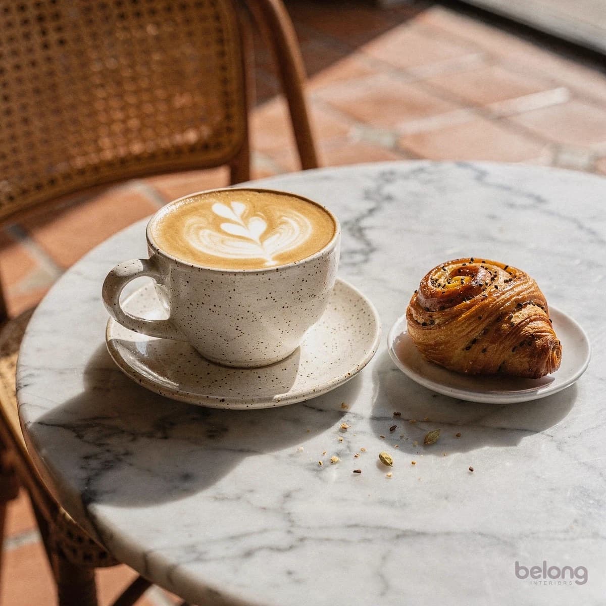 Cappuccino and a cardamom bun on a marble table