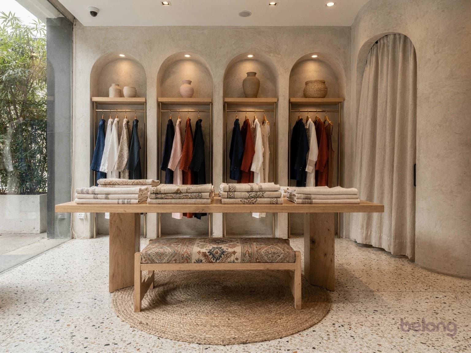 Handloom boutique with arched alcoves, an oak display table and a curtained fitting room