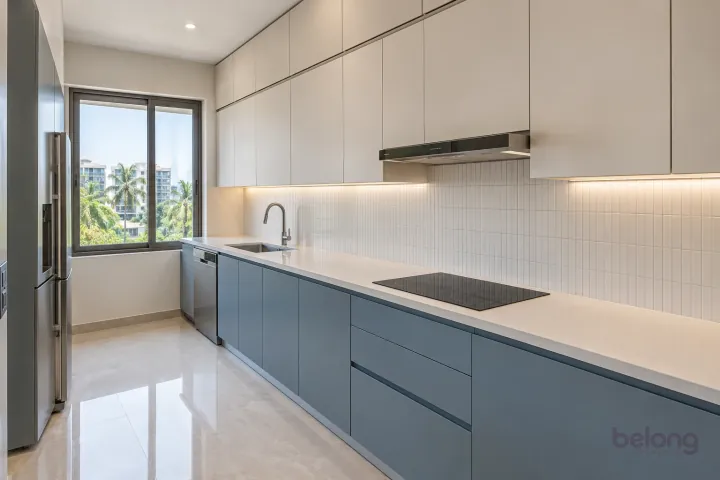 Compact blue and white kitchen with ceiling-height cupboards, a fitted dishwasher and clean closed storage.