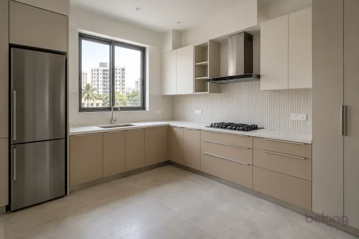 New modern compact L-shaped kitchen in champagne and oyster, with white fine-grain quartz worktops and pearl white narrow fluted ceramic tiles.