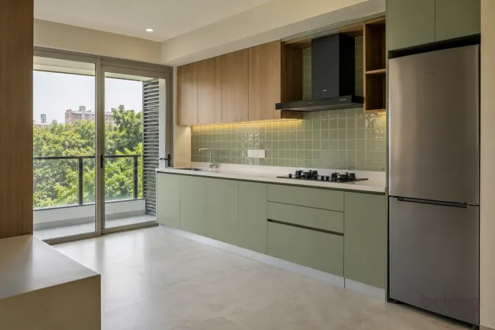 New modern compact straight kitchen in pistachio and cypress oak, with cream quartz worktops and soft pistachio square gloss tiles.
