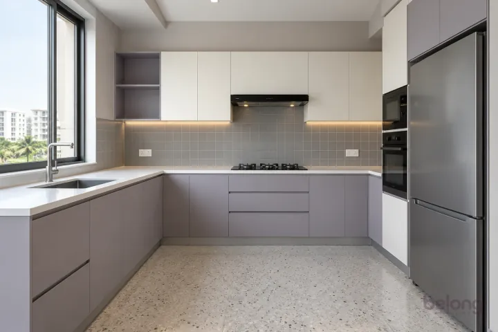 New modern compact L-shaped kitchen in lilac grey and warm white, with plain white quartz worktops and soft grey satin square tiles.