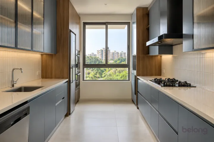 New modern parallel kitchen with a clear aisle in blue grey and warm walnut, with ivory quartzite-look porcelain worktops and warm-white vertical stacked ceramic tiles.