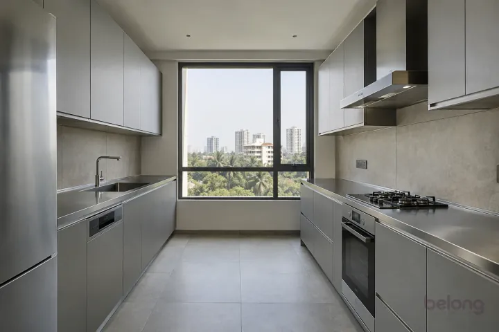 New modern parallel kitchen with a clear aisle in concrete grey and satin steel, with brushed stainless steel worktops and warm grey large-format porcelain.