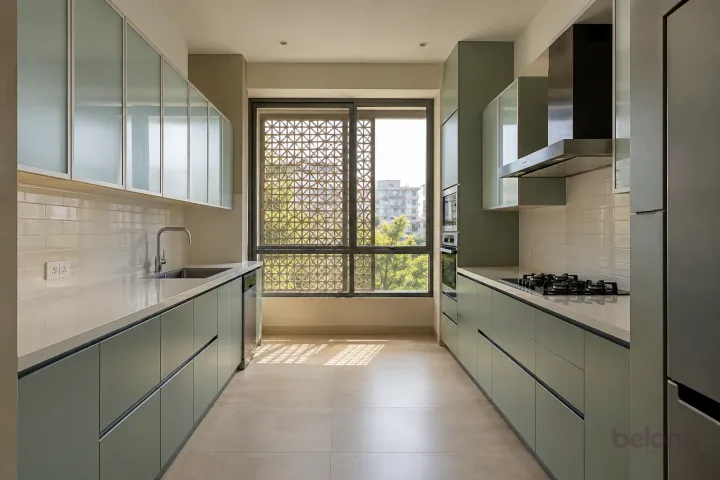 New modern parallel kitchen with a clear aisle in eucalyptus green and ivory glass, with cream quartz worktops and pale ivory horizontal ceramic rectangles.