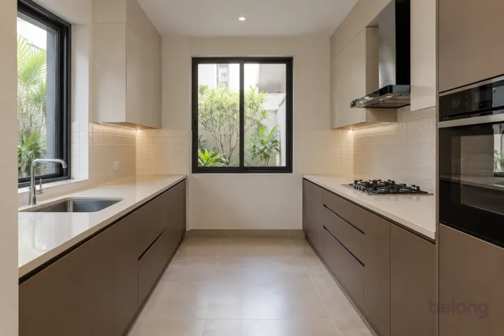 New modern parallel kitchen with a clear aisle in cocoa brown and linen, with ivory quartz worktops and warm-white square tiles with matching grout.