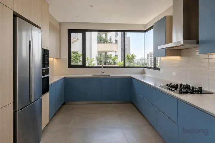 New modern generous U-shaped kitchen in denim blue and pale ash, with pale grey quartz worktops and ivory narrow rectangular tiles in horizontal stack.