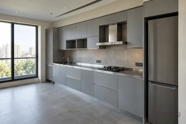 New modern compact straight kitchen in concrete grey and satin steel, with brushed stainless steel worktops and warm grey large-format porcelain.