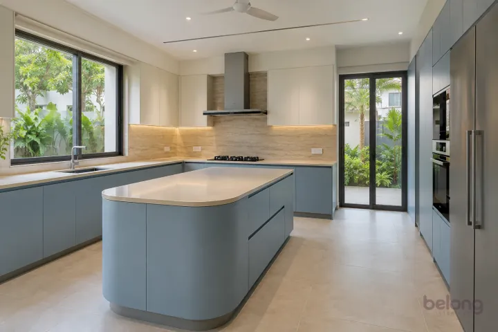 New modern villa kitchen with a central island in dove blue and pale stone, with ivory quartz worktops and travertine-look porcelain slab.