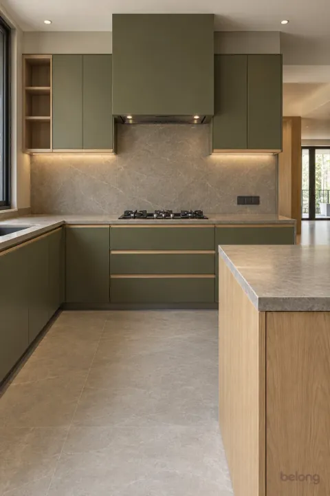 Olive peninsula kitchen with a boxed-in hood, with olive green and warm grey stone finishes, precise fitted joinery and pristine surfaces in a contemporary Indian home.