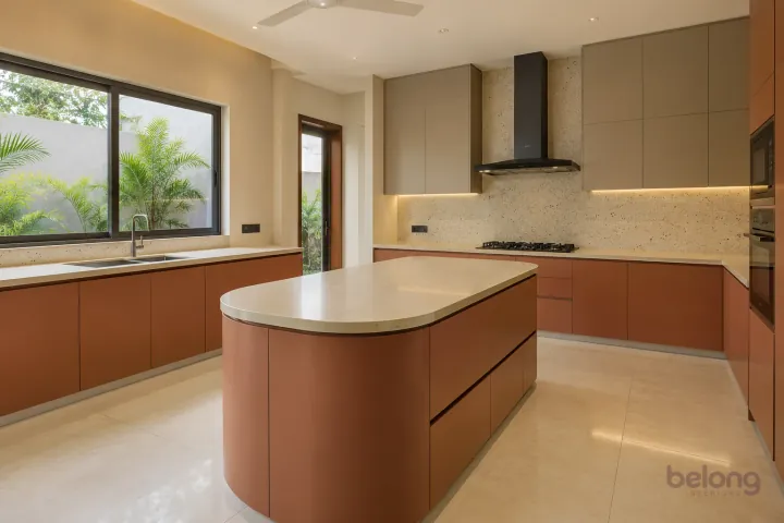 New modern villa kitchen with a central island in terracotta and warm taupe, with cream solid surface worktops and very pale beige fine-speckle terrazzo backsplash.