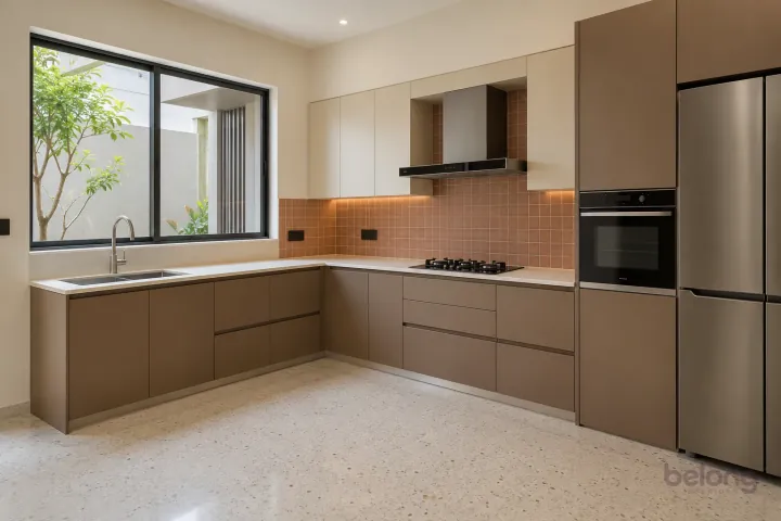 New modern compact L-shaped kitchen in clay and sand, with ivory solid surface worktops and small satin terracotta square tiles.
