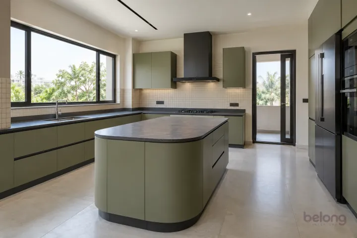 New modern villa kitchen with a central island in olive and charcoal, with honed charcoal quartz worktops and cream micro-grid ceramic tiles.