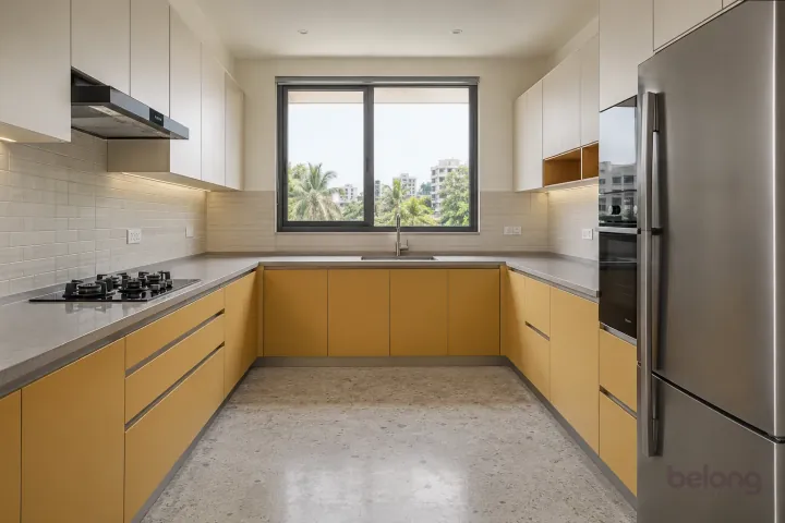New modern generous U-shaped kitchen in muted saffron and off-white, with pale grey quartz worktops and off-white small rectangular ceramic tiles.