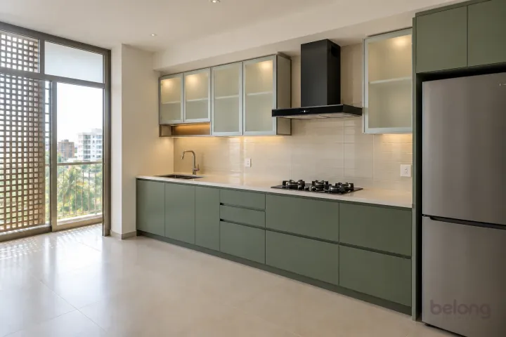 New modern compact straight kitchen in eucalyptus green and ivory glass, with cream quartz worktops and pale ivory horizontal ceramic rectangles.