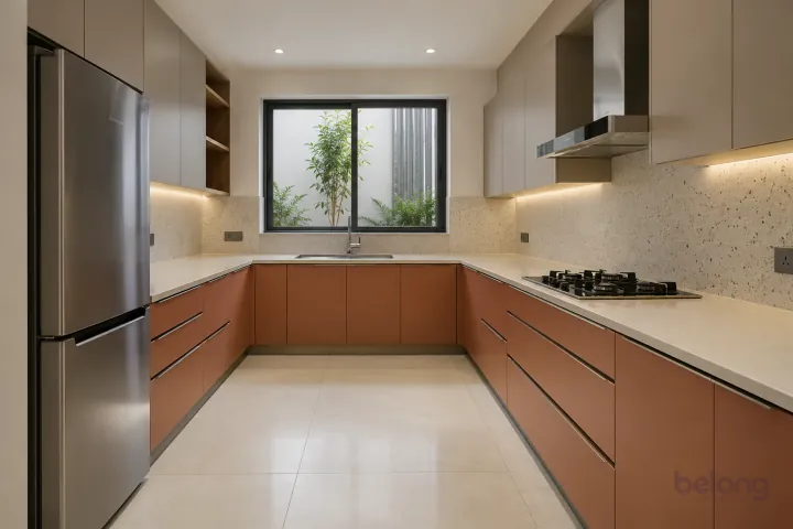 New modern generous U-shaped kitchen in terracotta and warm taupe, with cream solid surface worktops and very pale beige fine-speckle terrazzo backsplash.