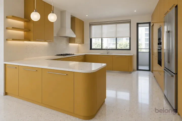 Ochre peninsula kitchen with white terrazzo, with ochre and white terrazzo finishes, precise fitted joinery and pristine surfaces in a contemporary Indian home.