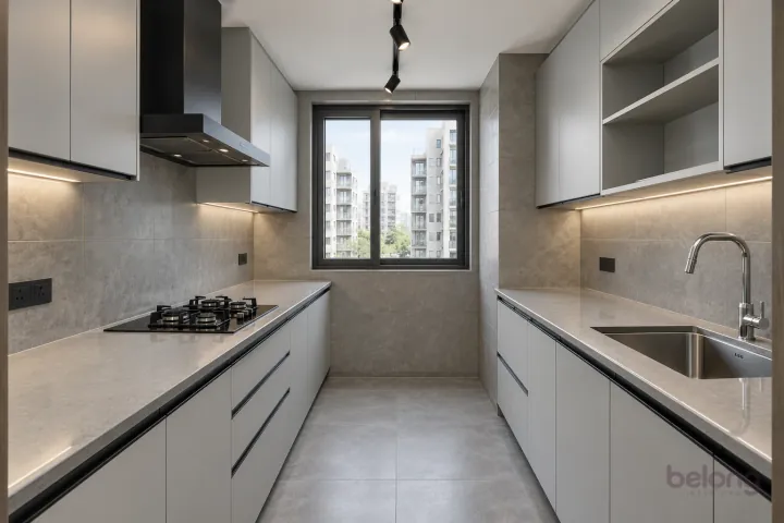 Light grey galley with black profile handles, with light grey and concrete-look tile finishes, precise fitted joinery and pristine surfaces in a contemporary Indian home.