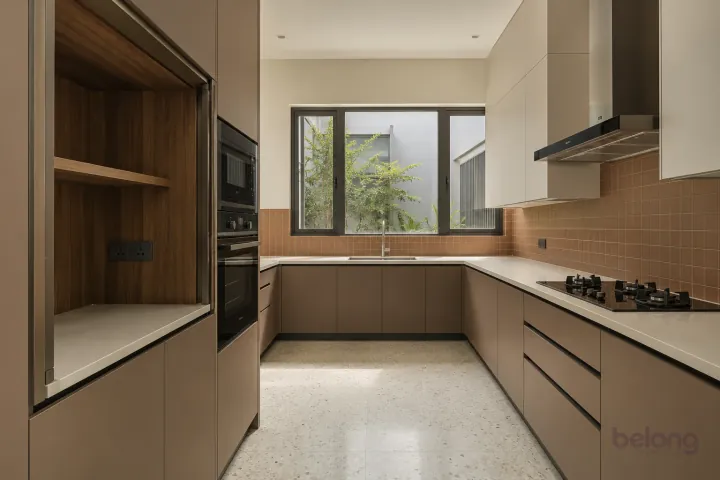 New modern pocket-door appliance garage in clay and sand, with ivory solid surface worktops and small satin terracotta square tiles.