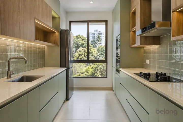 New modern parallel kitchen with a clear aisle in pistachio and cypress oak, with cream quartz worktops and soft pistachio square gloss tiles.