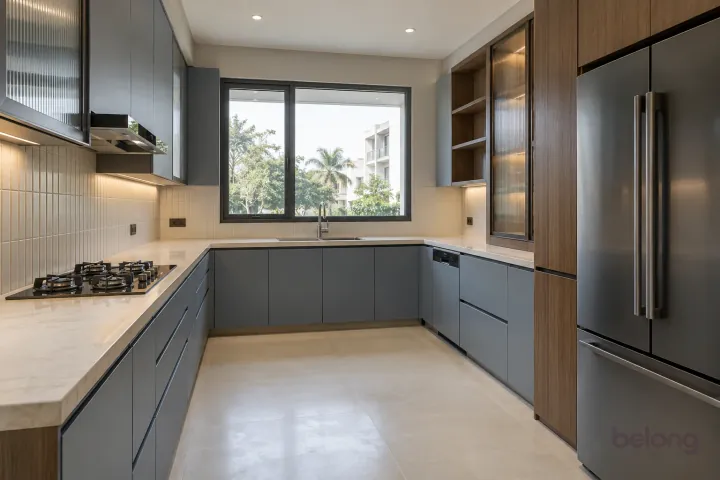 New modern generous U-shaped kitchen in blue grey and warm walnut, with ivory quartzite-look porcelain worktops and warm-white vertical stacked ceramic tiles.