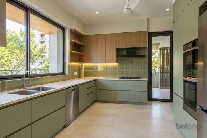 New modern double-bowl family sink in pistachio and cypress oak, with cream quartz worktops and soft pistachio square gloss tiles.