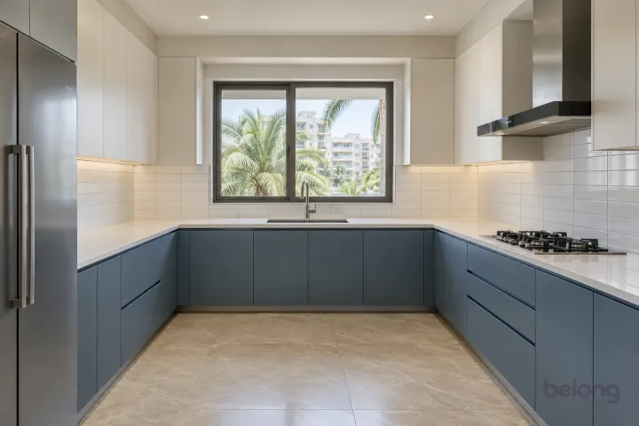U-shaped smoky-blue kitchen with white stacked rectangular backsplash tiles and quartz counters.