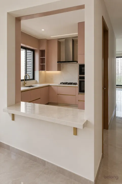 Dusty-pink kitchen with a framed serving hatch, with dusty pink and white quartz finishes, precise fitted joinery and pristine surfaces in a contemporary Indian home.