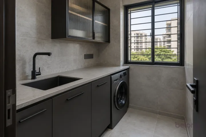 Charcoal utility with concrete-look tiles, with charcoal and concrete grey finishes, precise fitted joinery and pristine surfaces in a contemporary Indian home.