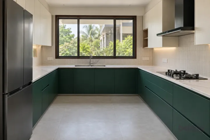 New modern generous U-shaped kitchen in emerald and ivory, with white marble-look sintered stone worktops and pale ivory vertical finger tiles.