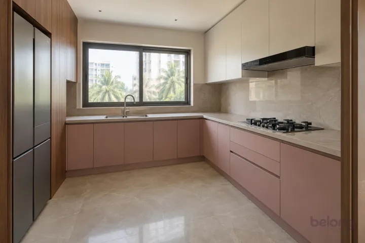 Small modern L-shaped kitchen with muted dusty-rose cabinets, walnut accents and pale stone counters.
